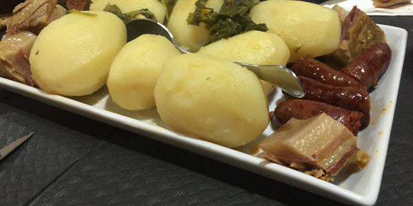 Fuente con patatas y chorizos en un cocido gallego